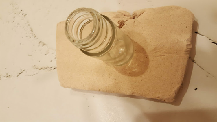 紙粘土の上に空き瓶を置く